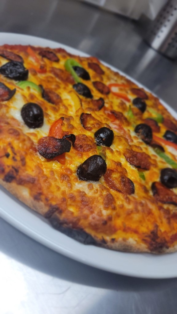 Pizza au feu de bois avec mozzarella fondante et basilic frais